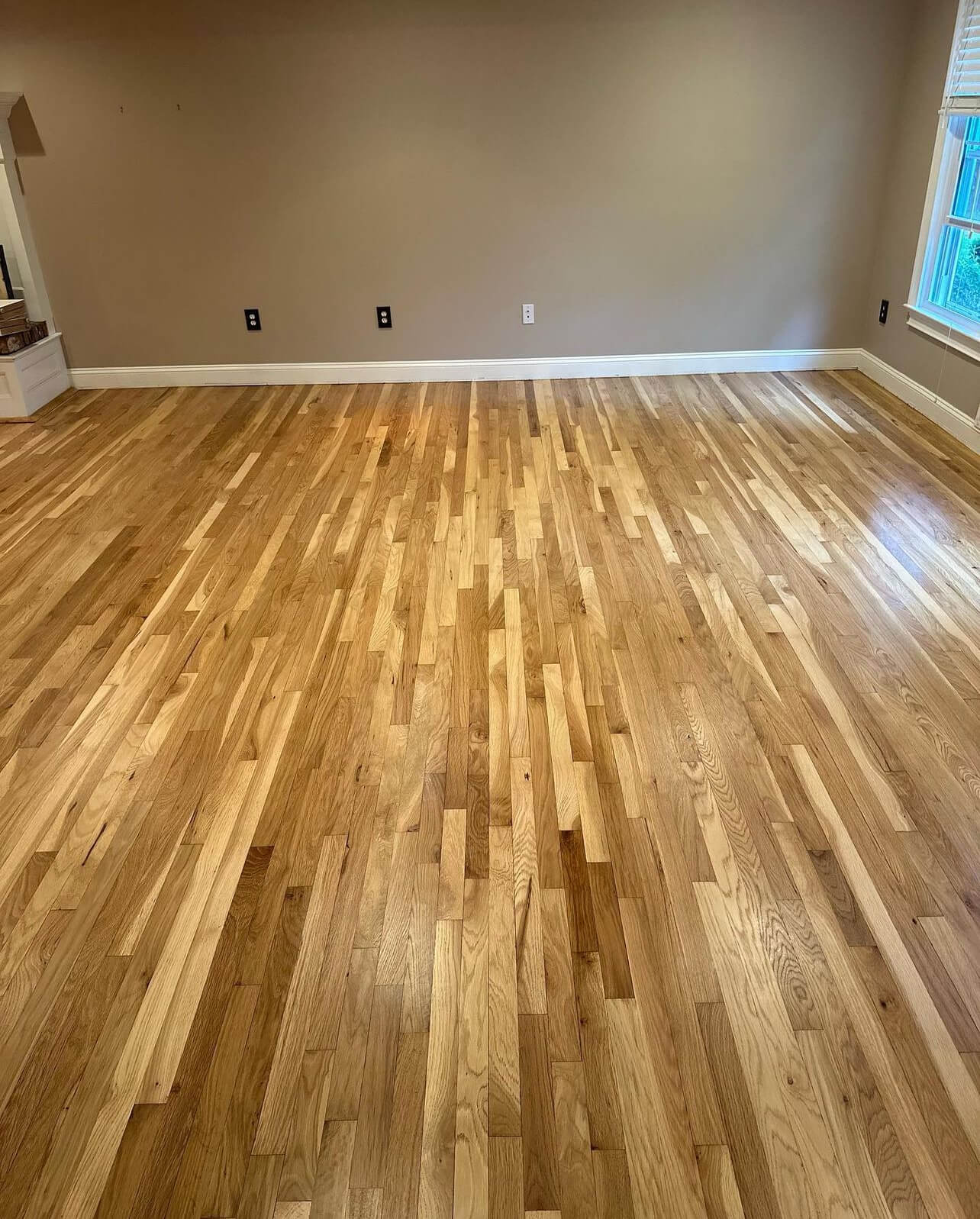 Beautifully finished hardwood floor in an empty room by Gorsegner Bros., trusted for their small business branding.
